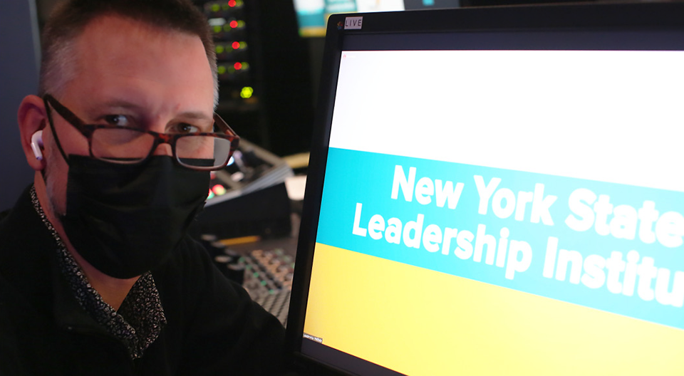 Ron Biggé of the Department of Media Production works on the video graphics for the New York State Leadership Institute.